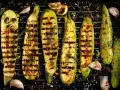 Zucchine grigliate perfette, condite con erbe aromatiche, aglio e scorza di limone, pronte per essere gustate.