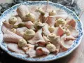 Piatto di vitello tonnato con salsa cremosa, capperi e guarnizioni.