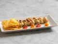 Involtini alla messinese su uno spiedino, accompagnati da patatine croccanti e pomodorini confit.