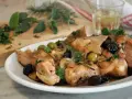 Piatto di coniglio alla cacciatora in bianco, con olive verdi e nere, cipolle e rosmarino.