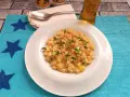 Un piatto di pasta patate e provola fumante, guarnito con prezzemolo fresco e un pizzico di peperoncino, pronto per essere gustato.