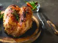 Succulento petto di pollo al forno, dorato e speziato, pronto per essere gustato con erbe aromatiche e peperoncini.