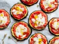 Pizzette di melanzane al forno, con pomodoro, mozzarella filante e un filo d'olio. Un antipasto sfizioso e leggero.