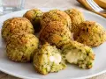 Polpette di zucchine dorate e croccanti, una ripiena di formaggio filante.