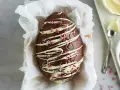Un magnifico uovo di Pasqua fatto in casa, decorato con cioccolato bianco e granella rosa.