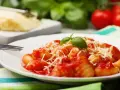 Gnocchi al pomodoro, un piatto semplice e gustoso, con basilico fresco e parmigiano grattugiato.