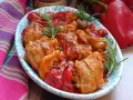 Un invitante pollo con peperoni alla siciliana, arricchito da olive e rosmarino, servito in un piatto decorato.