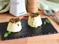 Due tortini di ricotta al forno, dorati e profumati, serviti su ardesia con basilico e peperoncino.