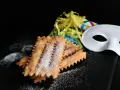 Chiacchiere siciliane spolverate di zucchero a velo, pronte per il Carnevale. La ricetta perfetta per festeggiare!