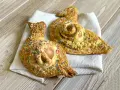 Due cuddure cu l'ova, dolci pasquali decorati con zuccherini colorati, riposano su un panno bianco.