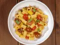 Un piatto invitante di pasta con pomodorini freschi, basilico e un filo d'olio.