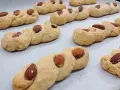 Intorchiate pugliesi ricetta originale: biscotti intrecciati dorati con mandorle e zucchero, pronti per essere gustati.