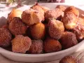 Un piatto colmo di castagnole ricetta della nonna, dorate e cosparse di zucchero. Un dolce che sa di casa e tradizione.