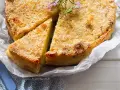 Gateau di patate alla siciliana dorato e croccante, guarnito con rosmarino fresco. Una fetta è già stata servita.