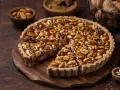 Torta croccante con un ripieno abbondante di nocciole e mandorle caramellate. Un vero piacere per gli amanti dei dolci con nocciole.