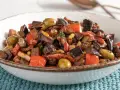 Caponata ricetta: melanzane, peperoni, olive e capperi in un piatto invitante.