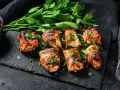 Bombette pugliesi succulente, avvolte in pancetta croccante e guarnite con prezzemolo fresco. Un assaggio di Puglia!