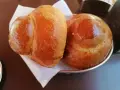 Due brioche col tuppo dorate e lucide, pronte per essere gustate con una granita.