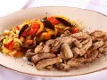 Straccetti di vitello succulenti serviti con un contorno colorato di verdure saltate, un piatto invitante e saporito.