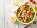 Deliziosa pasta fredda con tonno, pomodorini, olive e limone, perfetta per un pasto estivo.