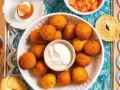Pallotte cacio e ova dorate e croccanti, servite con una salsa cremosa e contorni invitanti.