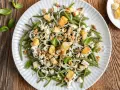 Deliziosa insalata di fagiolini con formaggio feta, noci croccanti, crostini e cipolla rossa. Un piatto fresco e saporito.