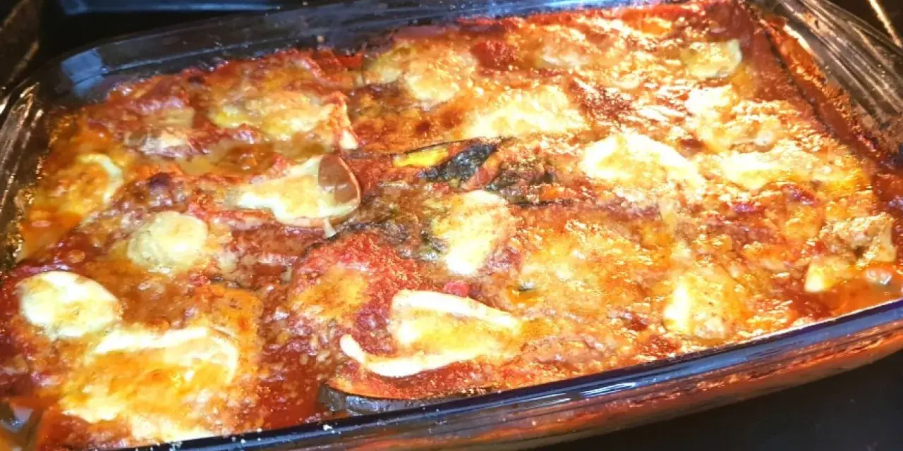 Parmigiana di melanzane non fritte appena sfornata, dorata e filante, pronta per essere gustata.