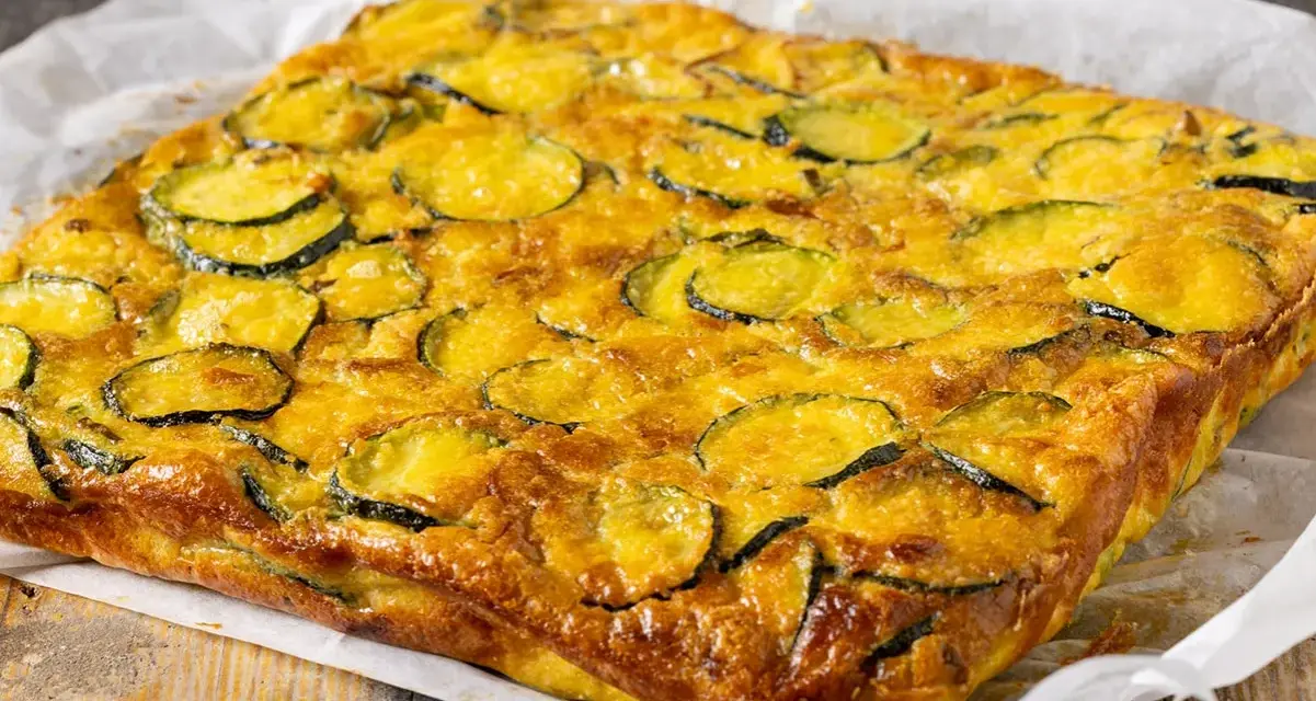 Frittata di zucchine dorata e invitante, con fette di zucchine ben visibili sulla superficie, pronta per essere gustata.