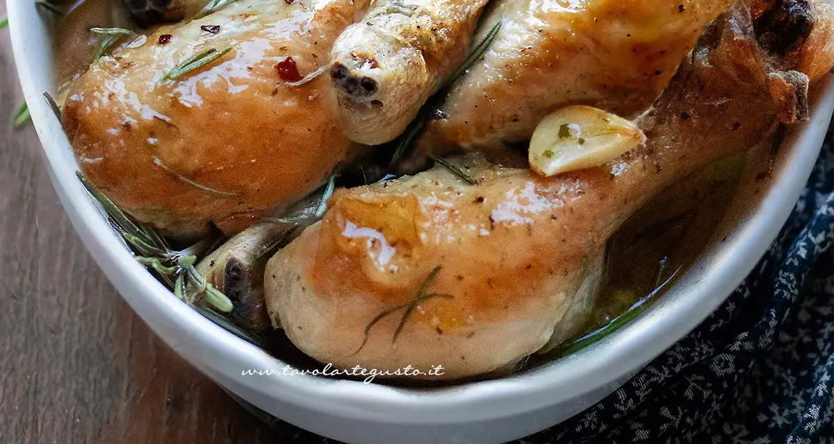 Cosce di pollo al forno succulente, dorate e profumate al rosmarino e aglio, servite in una ciotola bianca.