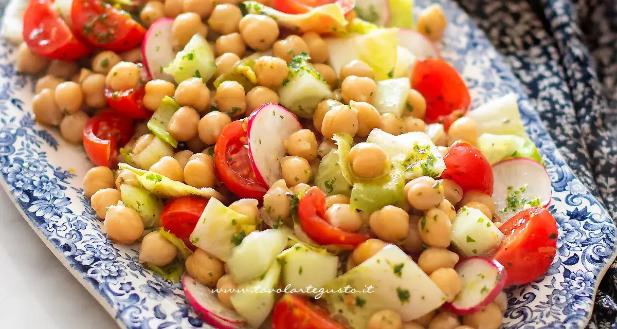 Deliziosa insalata di ceci fredda con pomodorini, cetrioli e ravanelli, condita con erbe fresche. Perfetta per un pasto leggero e gustoso.