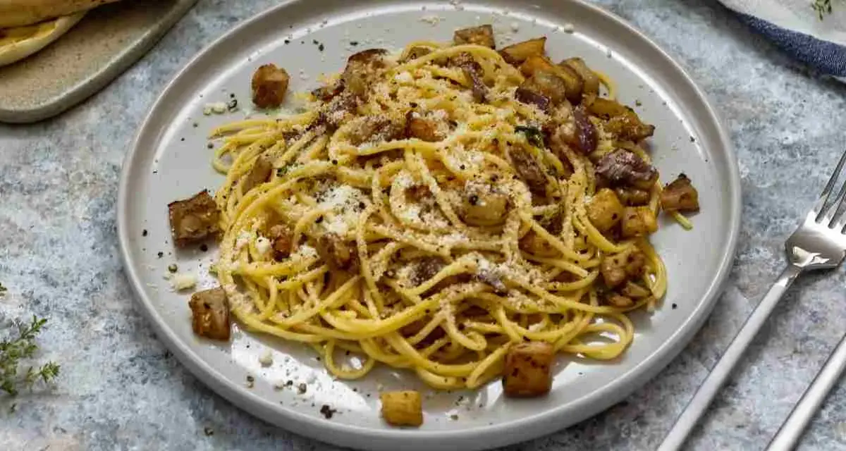 Spaghetti con melanzane fritte e ricotta salata, un sapore autentico di pasta alla siciliana.