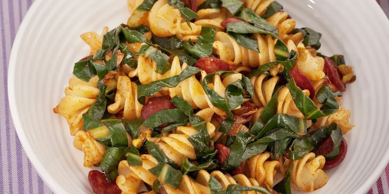 Fusilli conditi con bietole, salsiccia e un tocco di spezie. Un piatto saporito e colorato.