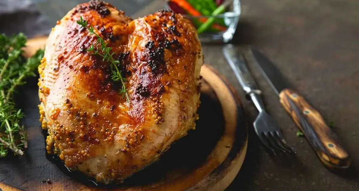 Succulento petto di pollo al forno, dorato e speziato, pronto per essere gustato con erbe aromatiche e peperoncini.