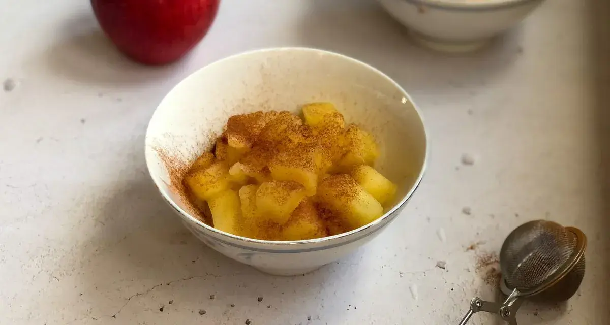 Mele cotte in pentola, dolci e profumate alla cannella, servite in una ciotola.