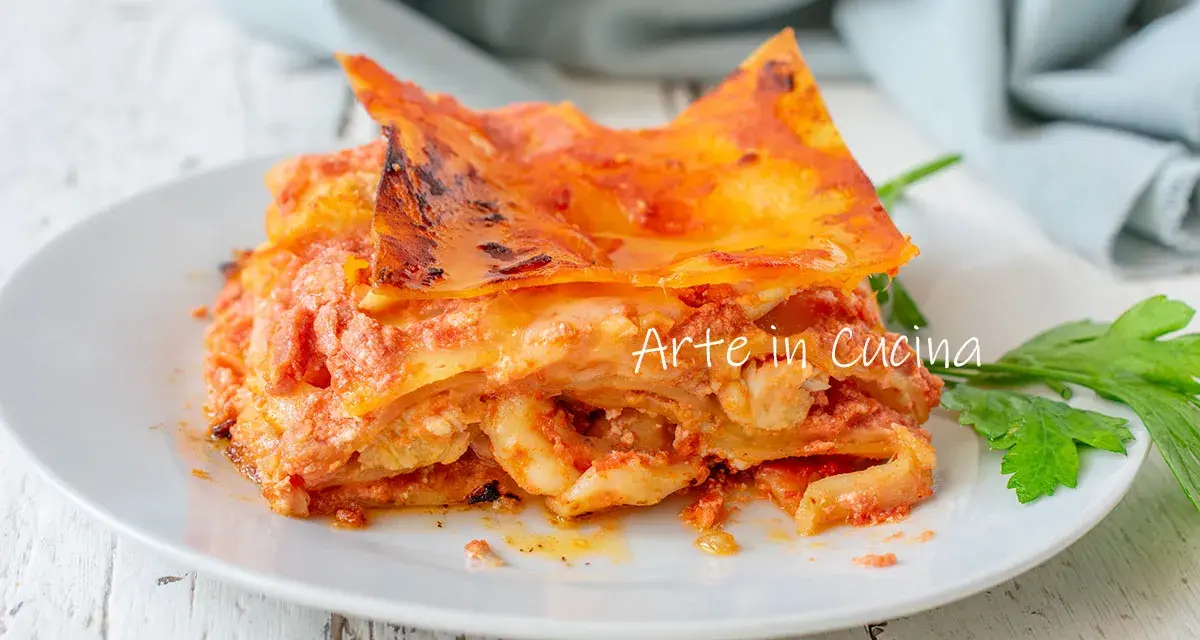 Una fetta di lasagna di mare napoletana, ricca e saporita, servita su un piatto bianco con un rametto di prezzemolo.