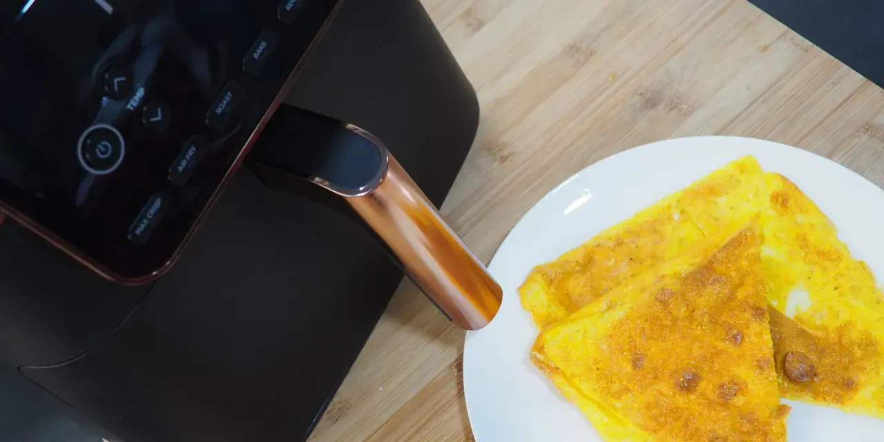 Frittata dorata appena sfornata dalla friggitrice ad aria Ninja, pronta per essere gustata.