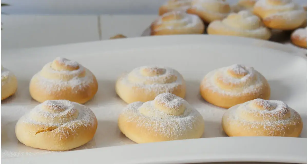 Biscotti a spirale cosparsi di zucchero a velo, perfetti con una tazza di caffè o tè, magari preparati con un tocco di latte condensato.