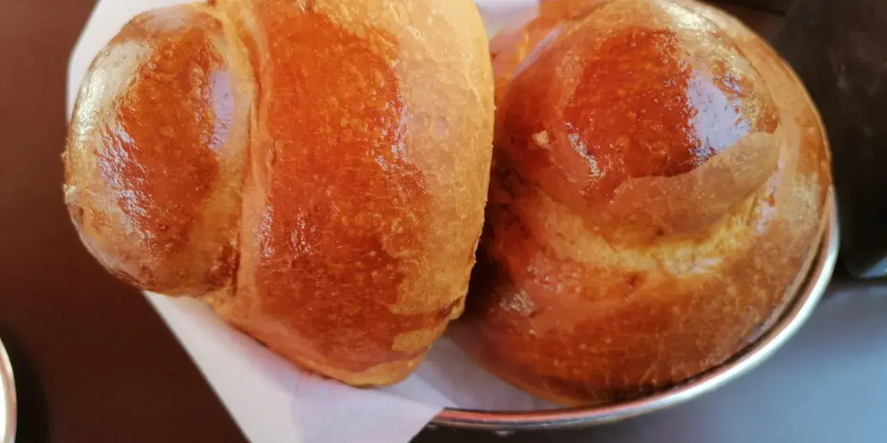 Due brioche col tuppo dorate e lucide, pronte per essere gustate con una granita.