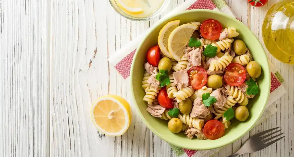 Deliziosa pasta fredda con tonno, pomodorini, olive e limone, perfetta per un pasto estivo.