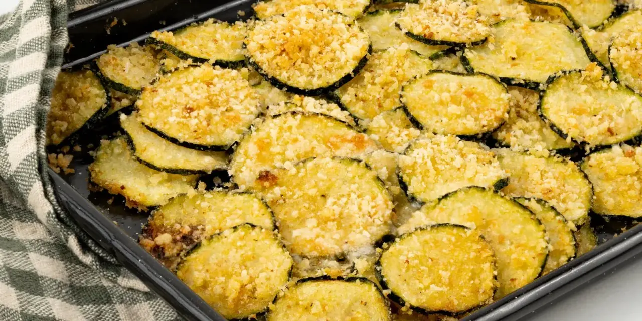 Fette di zucchine gratinate al forno, dorate e croccanti, pronte per essere gustate.