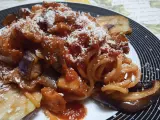 Un piatto invitante di pasta alla norma con melanzane fritte, sugo di pomodoro e ricotta salata grattugiata.