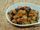 Melanzane al microonde, tagliate a cubetti e condite con pomodoro e spezie, servite in una ciotola bianca.