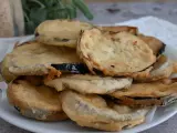 Piatto di melanzane fritte pastellate, dorate e croccanti, pronte per essere gustate.