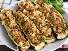 Zucchine ripiene al forno, dorate e croccanti, con un ripieno saporito e erbe aromatiche. Un piatto invitante e gustoso.