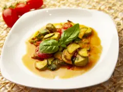 Zucchine in umido con pomodorini e basilico fresco, un piatto estivo profumato e saporito.