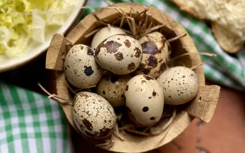 Un cesto di paglia contiene uova di quaglia sode, pronte per essere gustate. Accanto, un'insalata fresca e pane.