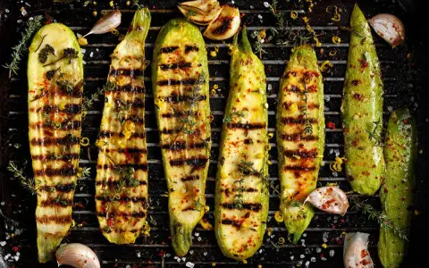 Zucchine grigliate perfette, condite con erbe aromatiche, aglio e scorza di limone, pronte per essere gustate.
