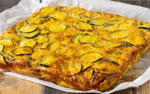 Frittata di zucchine dorata e invitante, con fette di zucchine ben visibili sulla superficie, pronta per essere gustata.