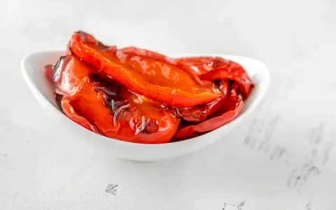 Peperoni al microonde, dolci e succosi, cotti alla perfezione in una ciotola bianca.