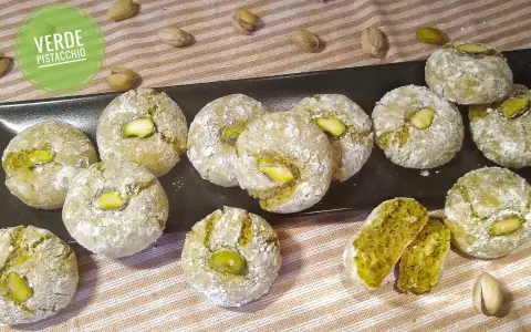 Biscotti al pistacchio siciliani, dolci e friabili, con un cuore verde intenso e un pistacchio intero in cima.